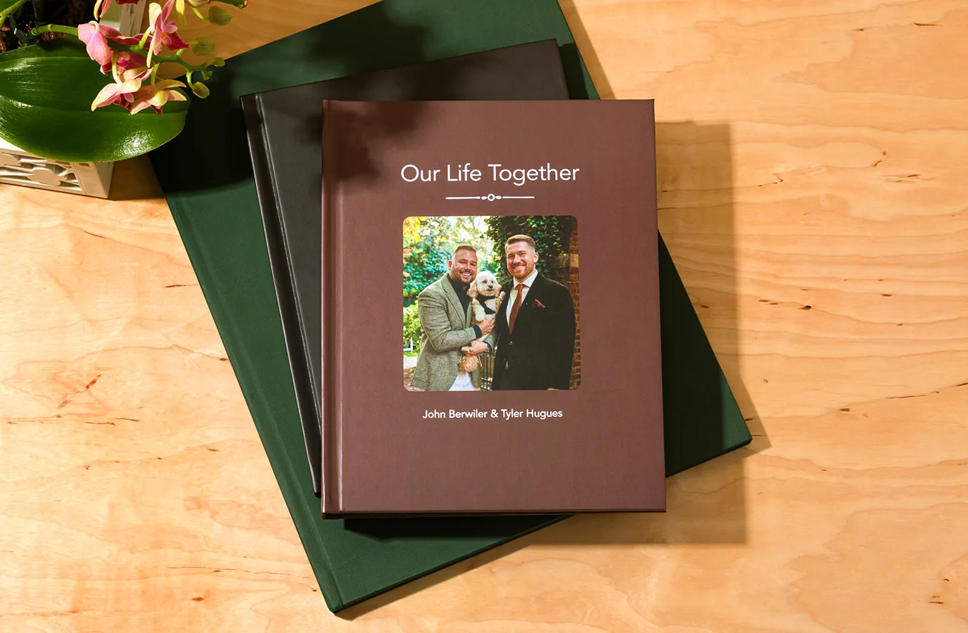 Three printed books with cover colors on a wooden surface.